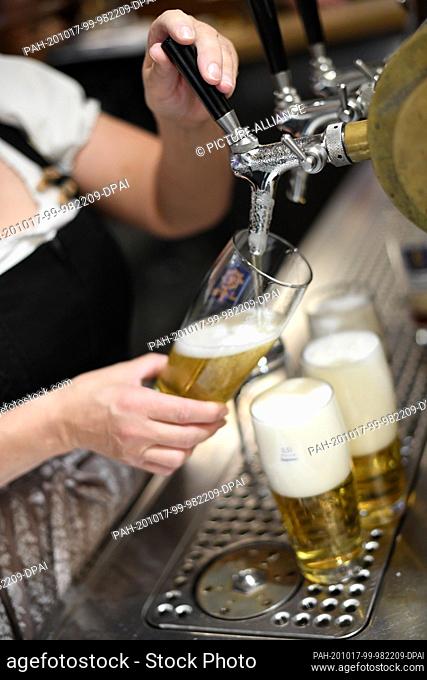 17 October 2020, Bavaria, Garmisch-Partenkirchen: A waitress taps beer in an inn. Almost half of the Bavarian districts and independent towns are now subject to...