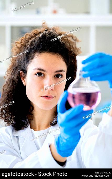Female scientist with beaker at chemistry lab