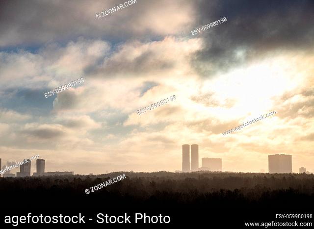 morning smoke fog over city park and high-rise houses on horizon
