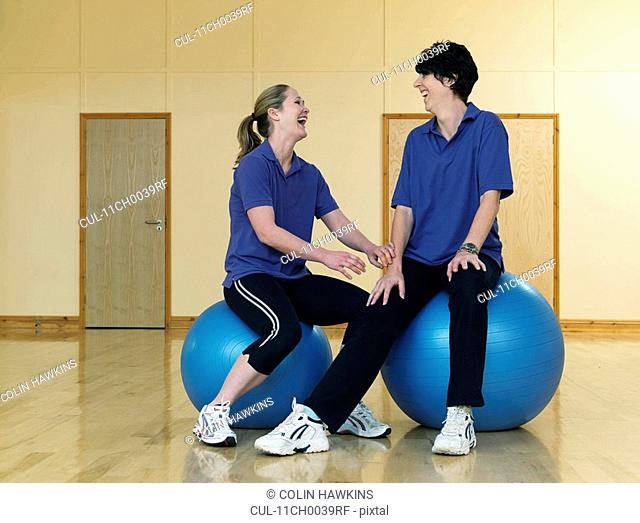 female gym instructors relaxing on balls