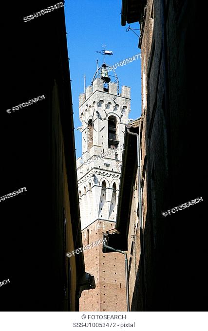 Torre del Mangia bell tower seen through darkened alleyway