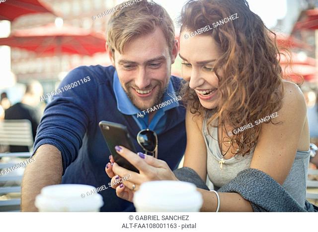 Couple looking at smartphone together outdoors