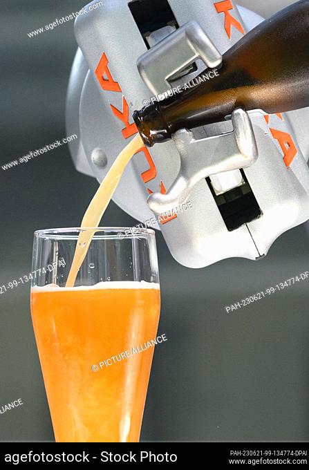 21 June 2023, Saxony, Dresden: A robot pours a glass of Hefeweizen beer at Silicon Saxony Day 2023 at Dresden International Airport