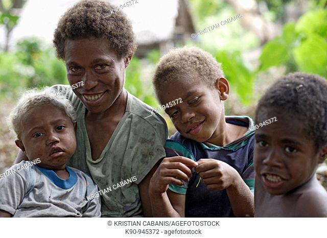 Shoulder and heads photograph of melanesian mother with her three kids, looking into the camera, Tanna island, Vanuatu,  Melanesia, South Pacific