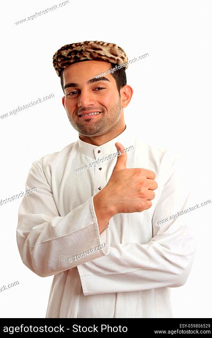 Ethnic mixed race man wearing a cultural clothing and vintage leopard skin topi hat. He is smiling and giving thumbs up approval success