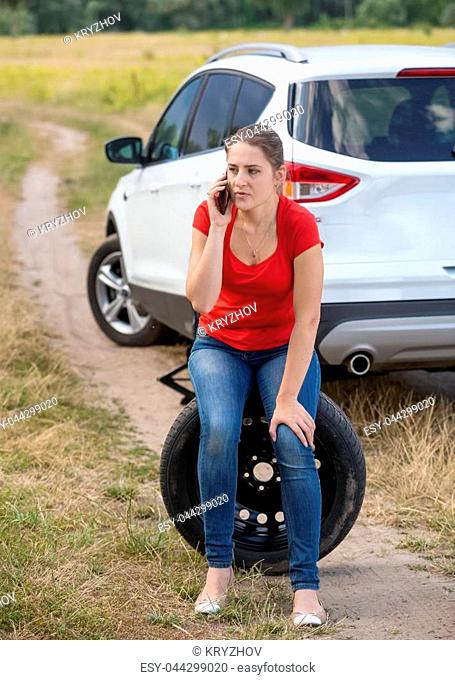 Upset woman got her car tire punctured and calling auto service for help