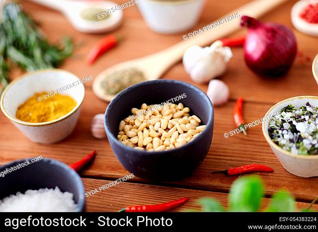 pine nuts in bowl and spices on kitchen table