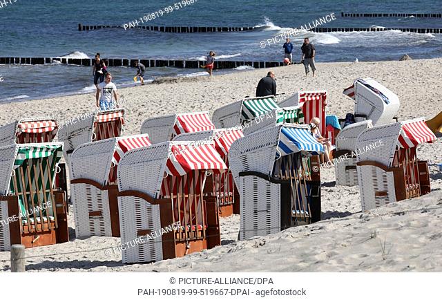 19 August 2019, Mecklenburg-Western Pomerania, Graal-Müritz: At the Baltic Sea beach many beach chairs are empty. Despite the sun there is no real beach weather