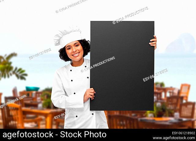 smiling female chef holding black chalkboard
