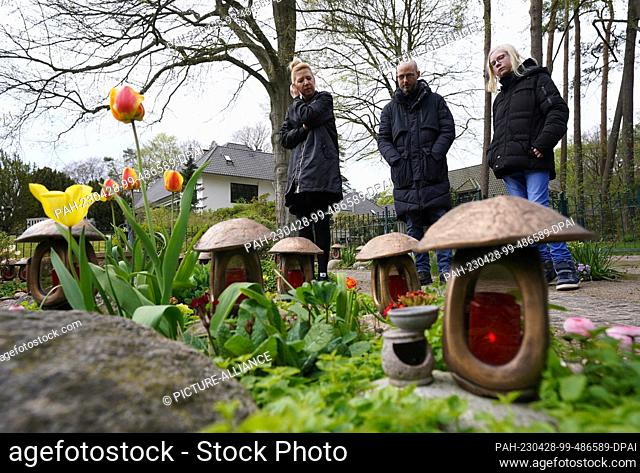 PRODUCTION - 27 April 2023, Hamburg: Angela and Tobias Migge and son Darian stand in the garden of remembrance of the Sternenbrücke children's hospice by the...