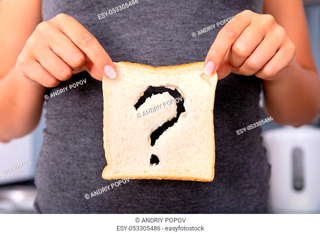 Mid-section Of A Woman Hands Holding Sliced Bread With Question Mark Sign
