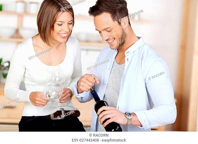 Young happy couple about to drink a wine at their home