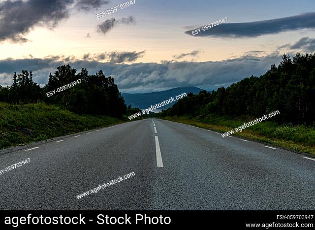 low angle view of a paved highway leading straight to the horizon in Swedish Lappland