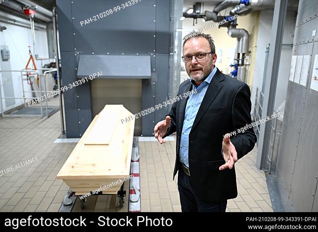 04 February 2021, Baden-Wuerttemberg, Tuttlingen: Armin Zepf, head of the Tuttlingen cemetery administration, stands next to a coffin that will be cremated...