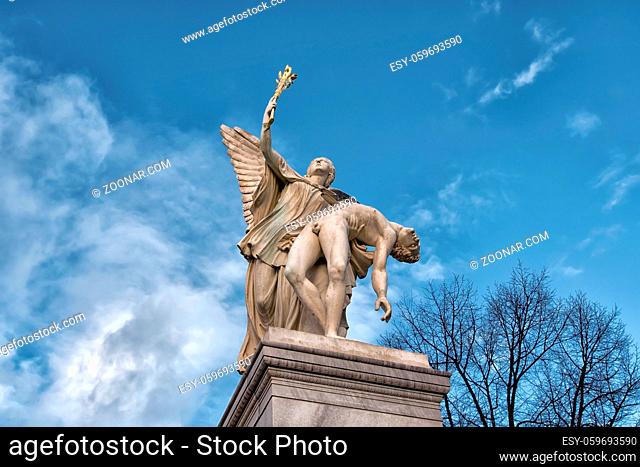 Berlin, Germany - December 9, 2019: The sculpture on the Schloss Bridge (Schlossbruecke) - Greek goddess Nike takes the fallen hero to Olympus