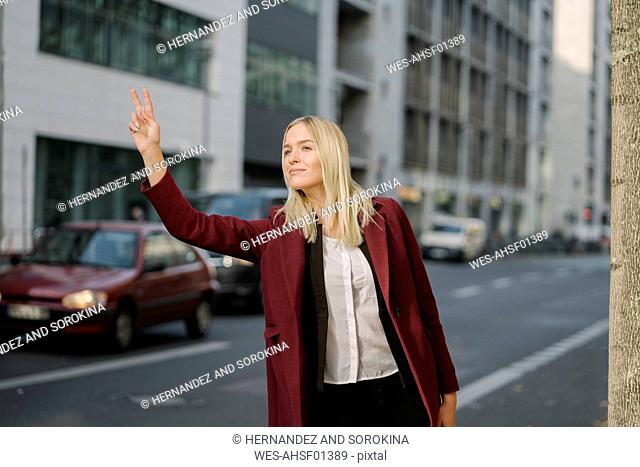 Stylish businesswoman catching taxi in the city