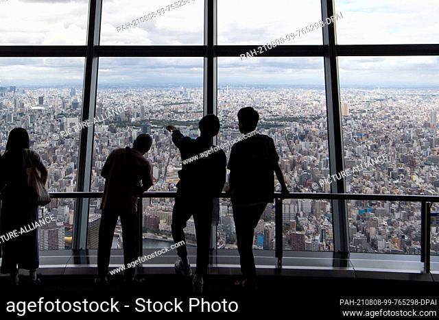 07 August 2021, Japan, Tokio: Visitors look out over Tokyo from the Tokyo Skytree, television tower in the Japanese capital Tokyo