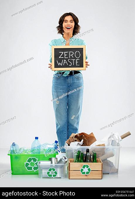happy woman sorting paper, metal and plastic waste