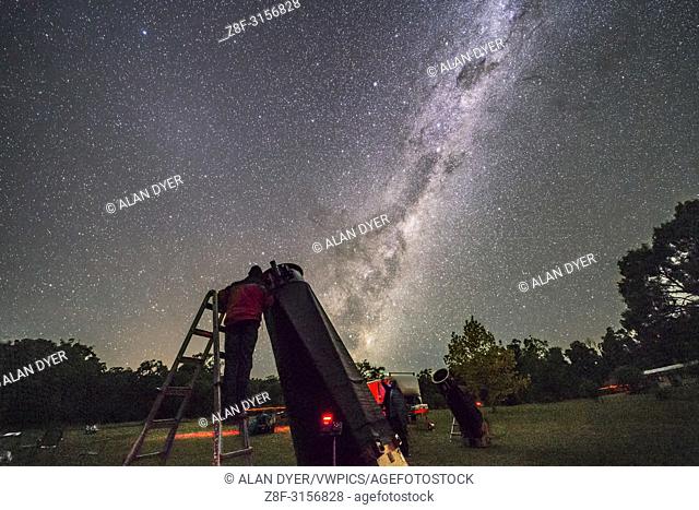 An observer (me!) at one of the large Dobsonian telescopes at the 2017 OzSky Star Party while the Dark Emu rises in the east in the sky. as a backdrop