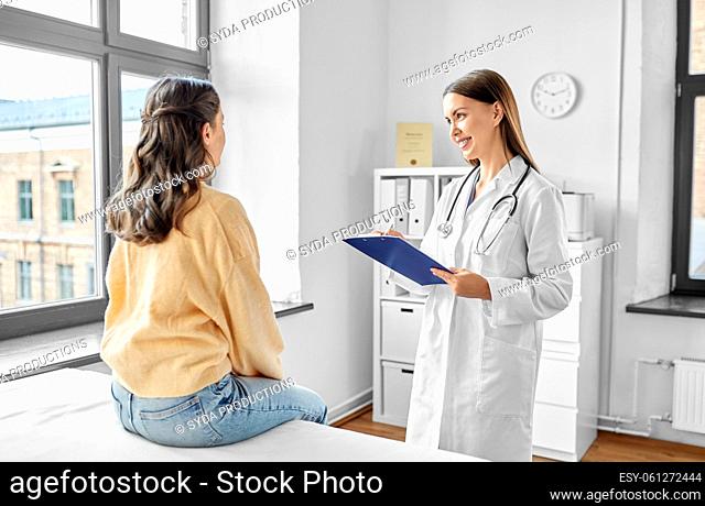 doctor with clipboard and woman at hospital