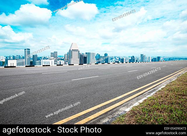 empty asphalt road and modern buildings in nanjing in blue sky