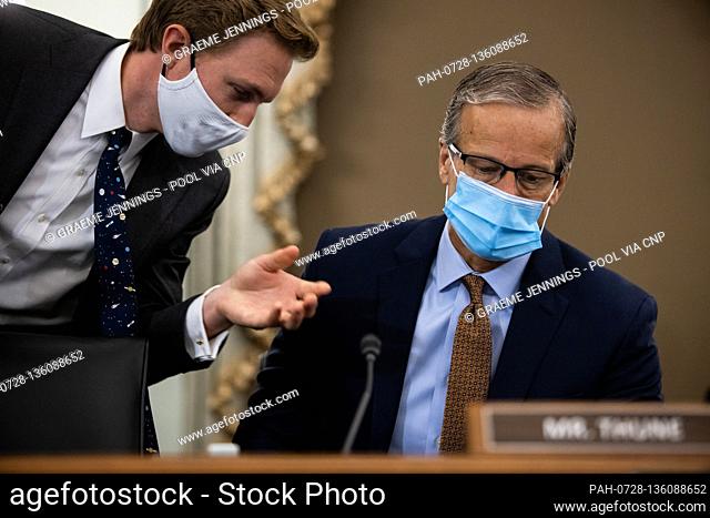 A Senate staffer confers with United States Senator John Thune (Republican of South Dakota), during a Senate Commerce, and Transportation Committee hearing on...