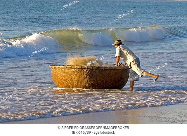 Vietnamese fisherman bringing in his basket boat, beach at Mui Ne, Vietnam, Southeast Asia, Asia