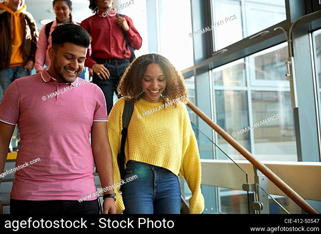 Smiling college students descending staircase