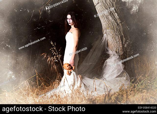 Horror Scene of a Woman Possessed holding a doll. High quality photo