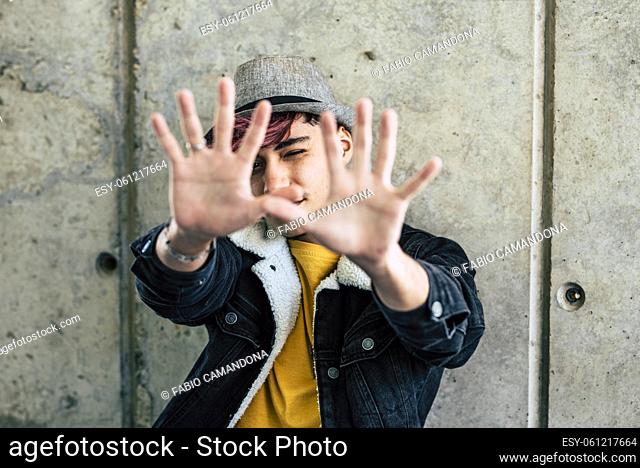 Young boy teen stop you with hands on in front of him - concept of rebel people - 18 man in casual clothes - teenager age lifestyle - save the planet and don't...