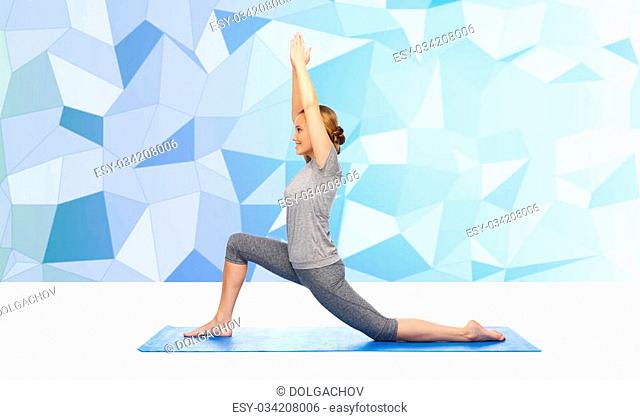 fitness, sport, people and healthy lifestyle concept - happy woman making yoga in low lunge pose on mat over blue polygonal background