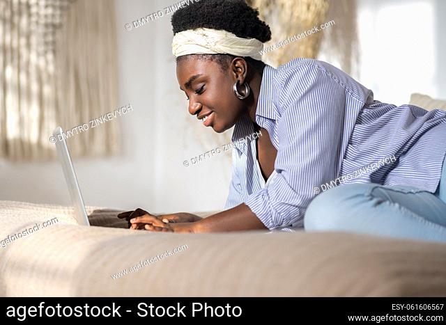 Online dating. African american woman chatting on internet and looking interested