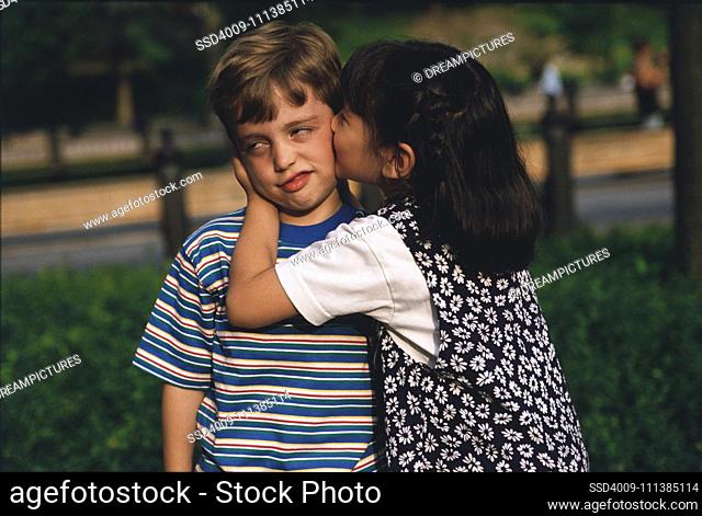Girl kissing reluctant boy