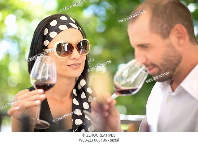 Man and woman examining red wine on a wine tasting session