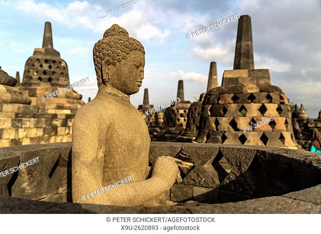 Buddha statue and stupas at the 9th-century Mahayana Buddhist Temple Borobudur near Yogyakarta, Central Java, Indonesia, Asia