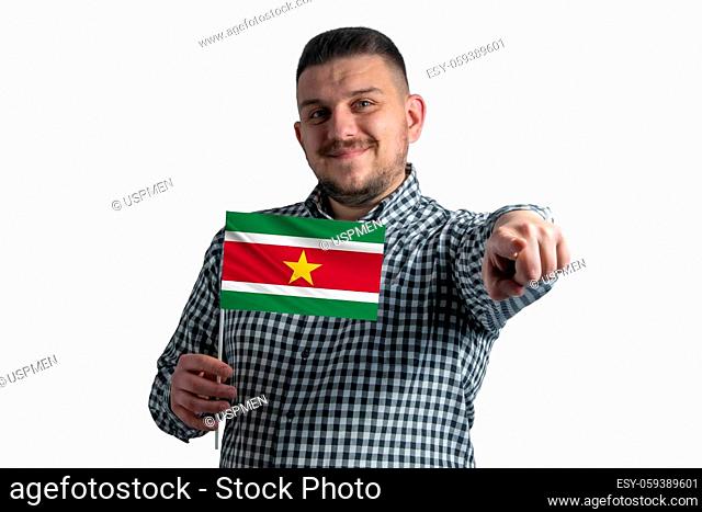 White guy holding a flag of Suriname and points forward in front of him isolated on a white background