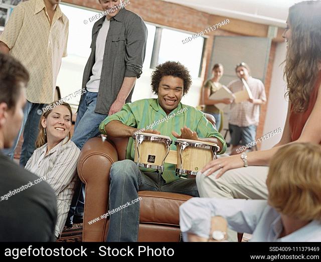 Teenage boy playing drums at party