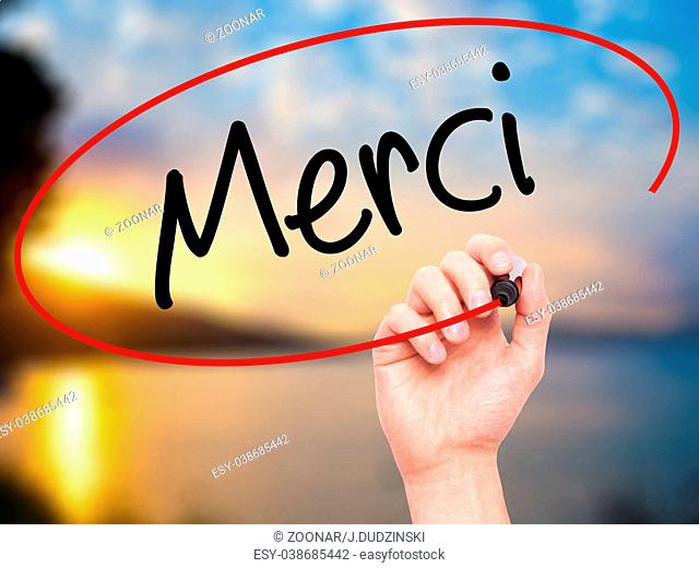 Man Hand writing Merci (Thank You In French) with black marker on visual screen