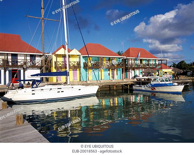 Redcliffe Quay. Area of restored historical buildings, boats moored at wooden jetty with line of buildings with colourfully painted facades behind