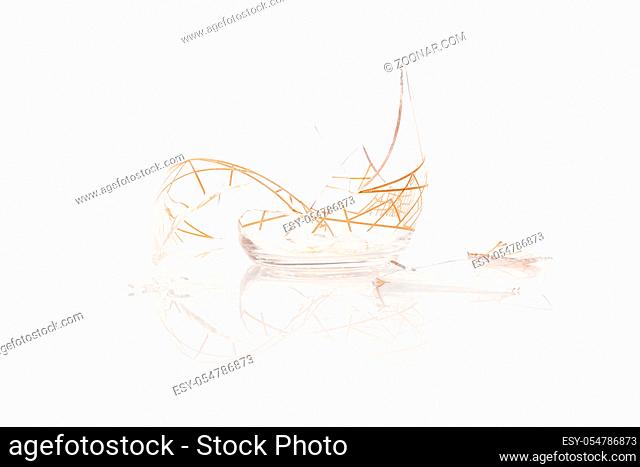 Broken empty glass isolated on white background with reflection, concept of luck