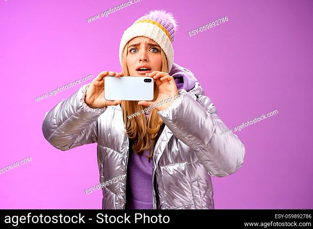 Intense worried blond girl holding mobile phone horizontal recording video capture moment share friends internet blog using smartphone camera shoot photograph...