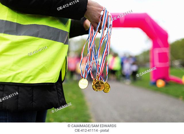 Volunteer holding medals at charity run