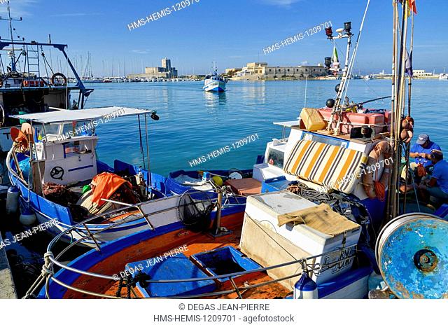 Italy, Sicily, Trapani, historic center, fishing harbor, trawlers with colorful wooden annd Castle Colombres of the 3rd century in the background