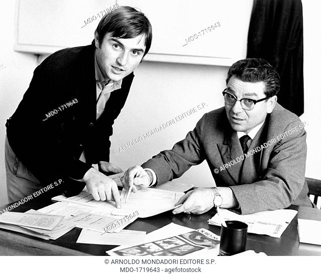 Giuliano Cederle with a teacher. Italian singer Giuliano Cederle and a teacher at the Istituto tecnico per geometri pointing at some papers