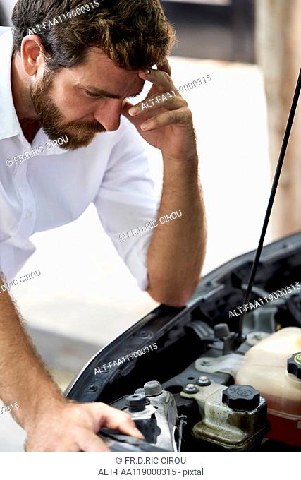 Man looking at car engine