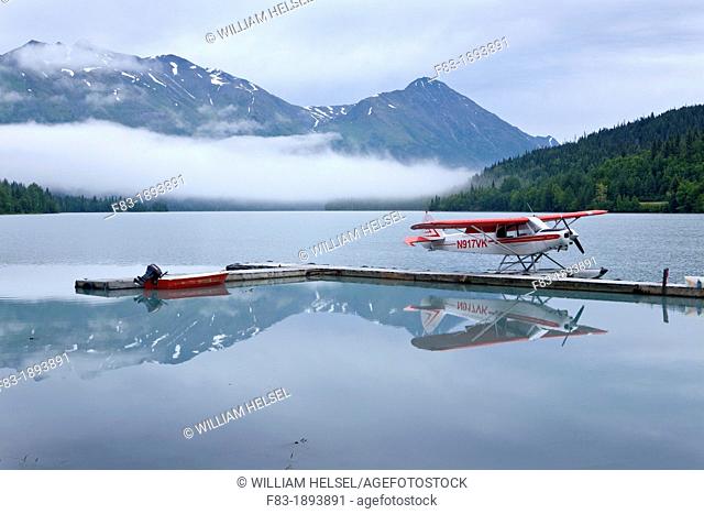 Float plane and boat beside dock, Upper Trail Lake, Moose Pass, Kenai Peninsula, Alaska, USA, late August
