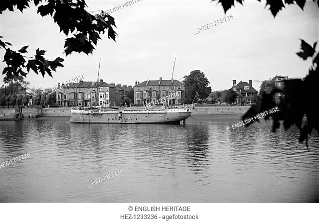 Ship moored on the Thames at Hammersmith, London, c1945-1965. A side view of the training ship, the 'Stork', moored at Hammersmith and viewed from the opposite...