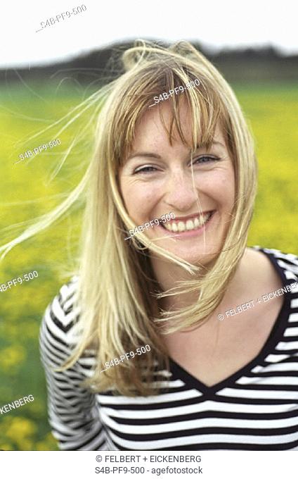 Lachende blonde Frau in einem gestreiften Shirt - Blumenwiese - Fruehling , Laughing blonde Woman in a striped Shirt  - Flower-Meadow - Spring ,  fully-released