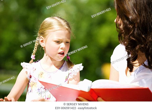 Image of cute girl and her mother playing in park