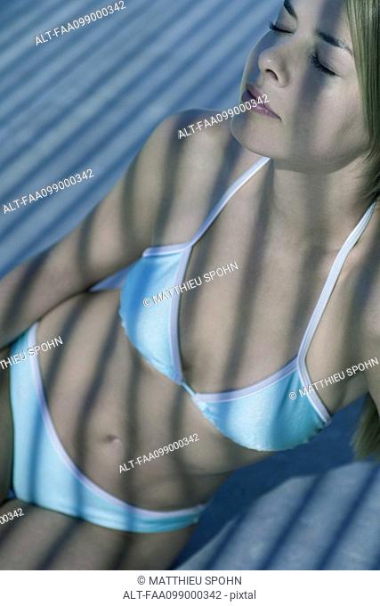 Young woman in bikini, eyes closed